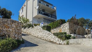 A multi-story building with balconies, a stone wall, and greenery. - Goreta in Ražanj - Mittel-Dalmatien / Goreta in Ražanj - Appartement für 4 Personen AP2 (Ražanj)