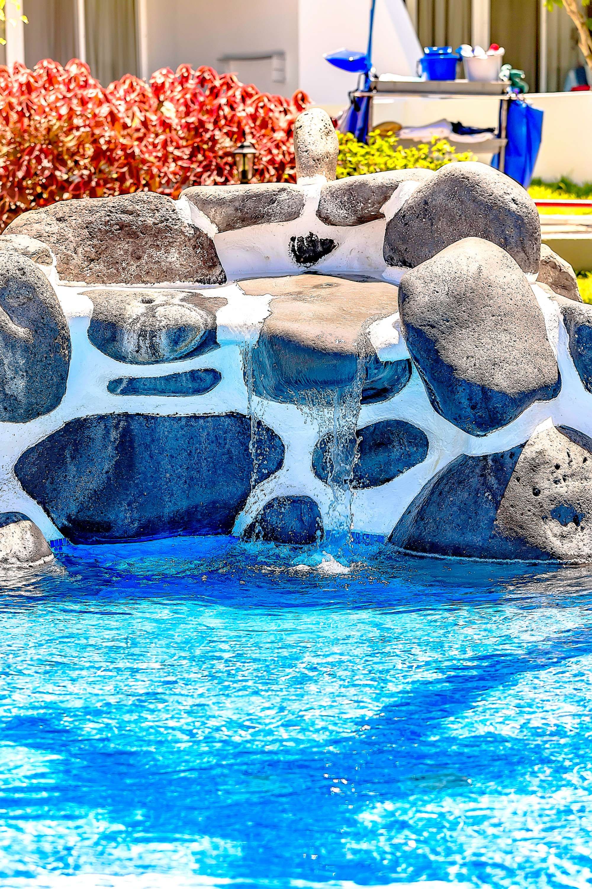 A pool with a rock feature and a waterfall.