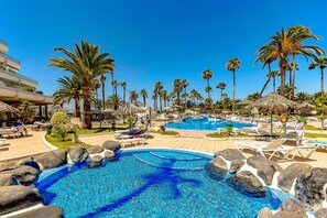 A resort with multiple swimming pools, palm trees, and lounge chairs. - Apartment in complex Altamira with direct sea view (Costa Adeje)