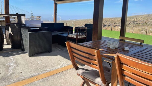 An outdoor patio with a grill, seating area, and a view of the landscape. - Casa rural con vistas maravillosas en Arico (Santa Cruz de Tenerife)