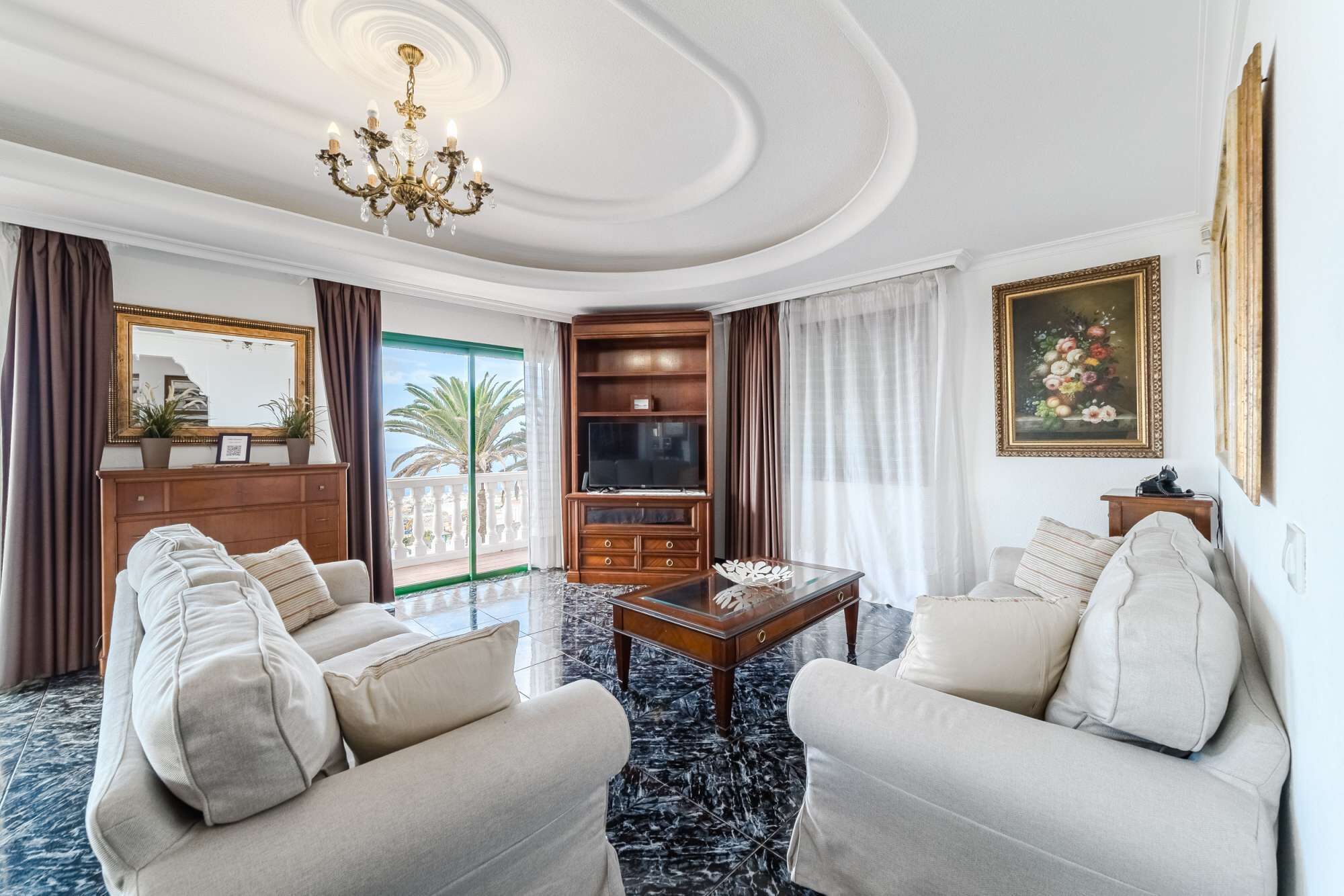 Un salón amplio con un gran sofá, un televisor y una mesa de centro decorativa.