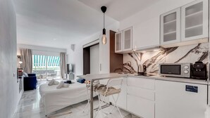 A modern kitchen with a marble backsplash, a microwave, and a coffee machine. - Graceful brand new studio in Altamira (Adeje)