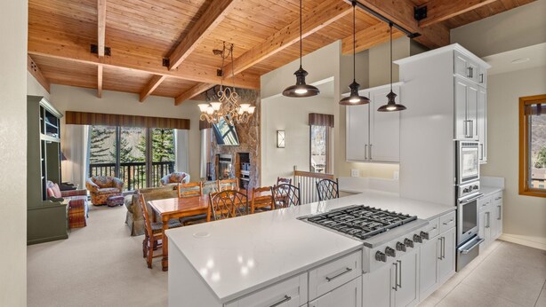 A spacious kitchen with a large island, white cabinetry, and a wooden ceiling. - Snowmass Getaway Wraparound Decks & Valley Views - 229 #35 by RedAwning (Snowmass Village)