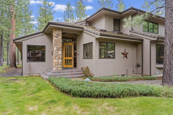 A modern two-story house with a stone entrance, large windows, and a well-maintained lawn. - Glaze Meadow 376 3 Bedroom Home by RedAwning (Sisters)