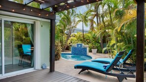 A covered outdoor area with a pool, lounge chairs, and tropical plants. - **MARINER’S HIDDEN HAVEN** Waterfront & Pool + Last Key White Glove Service... (Key West)