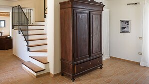 A staircase with a black railing, a wooden cabinet with two doors, and a tiled floor. - Villa Elettra 12+2 by Marche Holiday Villas (San Costanzo)