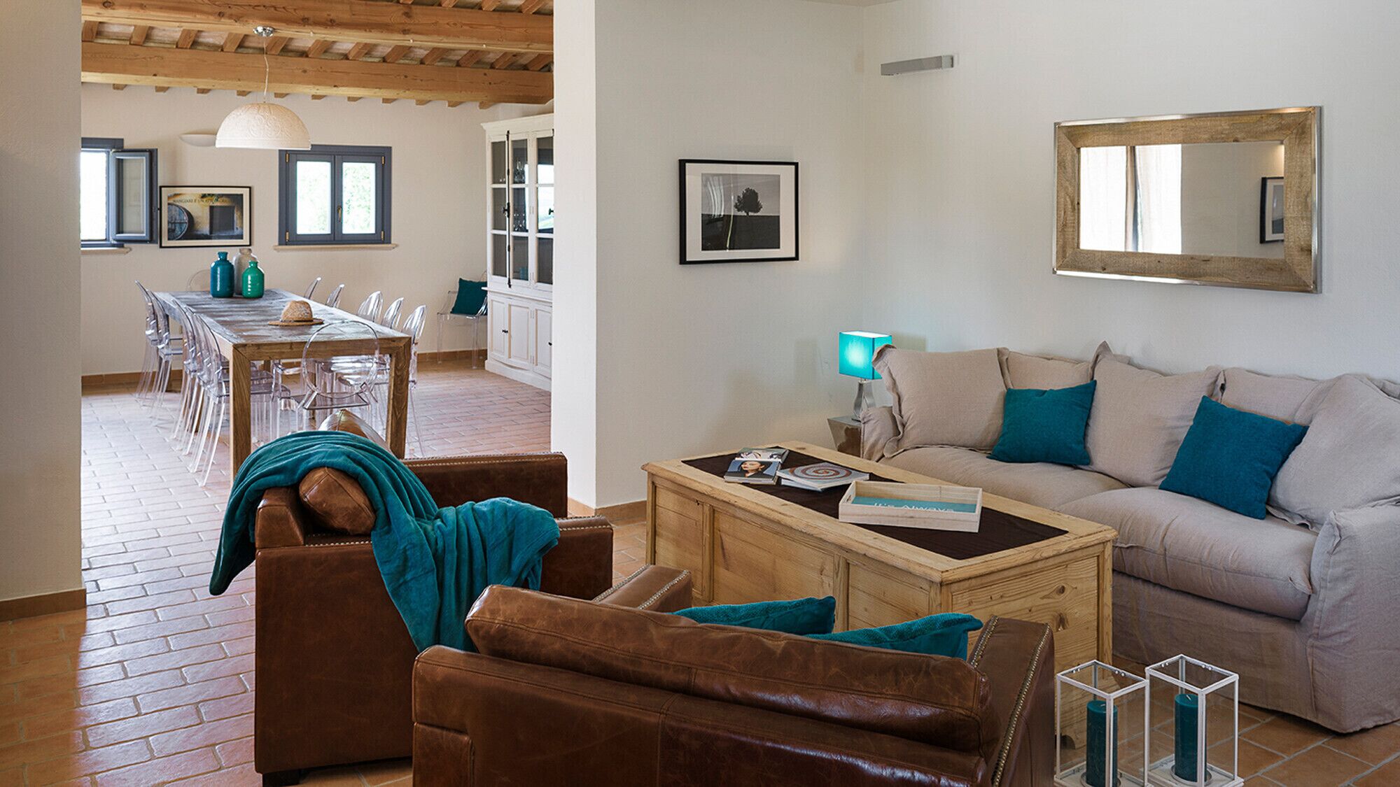 A living room with a sofa, coffee table, and a dining area with chairs and a table.