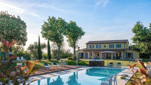 A large house with a swimming pool, surrounded by trees and outdoor furniture. - Villa Elettra 12+2 by Marche Holiday Villas (San Costanzo)