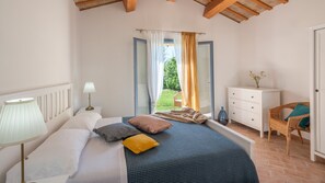 Une chambre à coucher comprenant un lit, une table de chevet, une commode et une chaise.