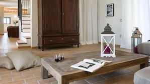 A living room with a wooden coffee table, a cabinet, a sofa, and a pair of cushions. - Villa Elettra 12+2 by Marche Holiday Villas (San Costanzo)