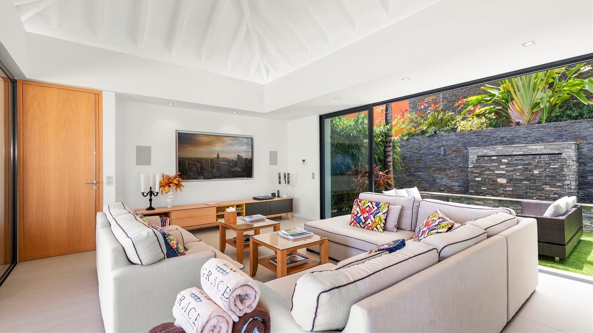 Un salon moderne avec un canapé, une table basse et un tableau représentant un paysage urbain accroché au mur.
