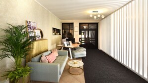 Een moderne woonkamer met een bank, een salontafel en een kamerplant.