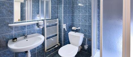 A bathroom with a white sink, a toilet, and a mirror.