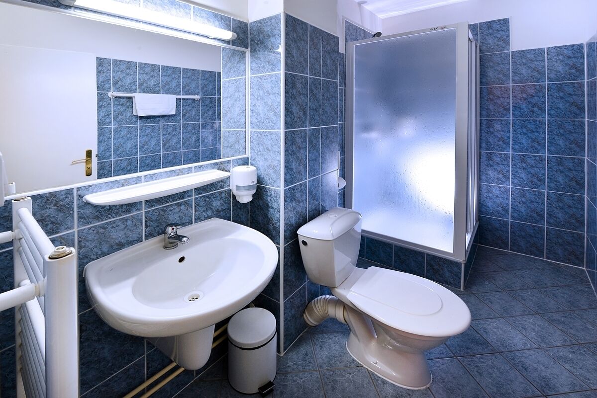 A bathroom with a sink, toilet, and shower.
