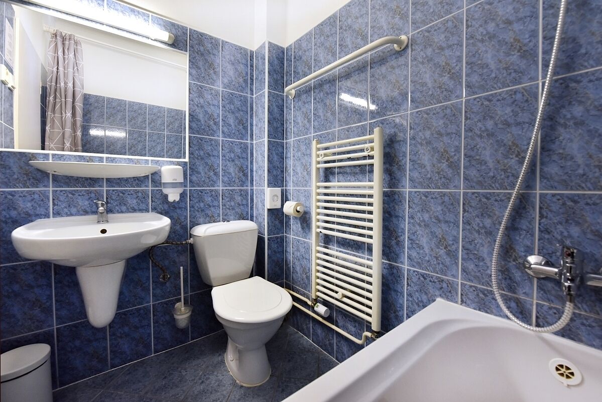 A bathroom with a sink, toilet, bathtub, and a towel rack.