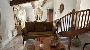 A living room with a wooden ceiling, a sofa, a coffee table, and a staircase. - Villa in a green setting, not overlooked, facing the village of Bargemon (bargemon)