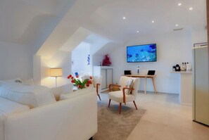 Relax in this stylish living room with a sofa, coffee table, flat-screen TV, and desk.