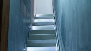A staircase with a metal railing and lights along the steps. - Kastren Rooms (Chania)