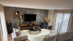A modern living room with a large flat-screen TV, a round coffee table, and a sofa set. - Villa design swimming pool Avignon festival (Avignon)
