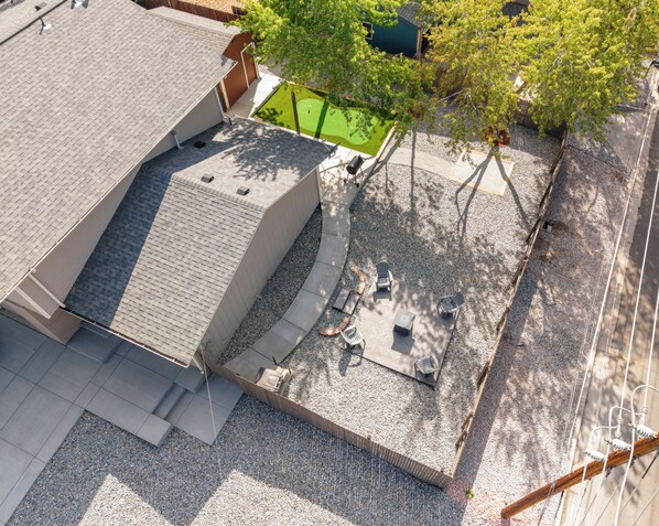 A rooftop patio with a barbecue grill, seating area, and a small green space.