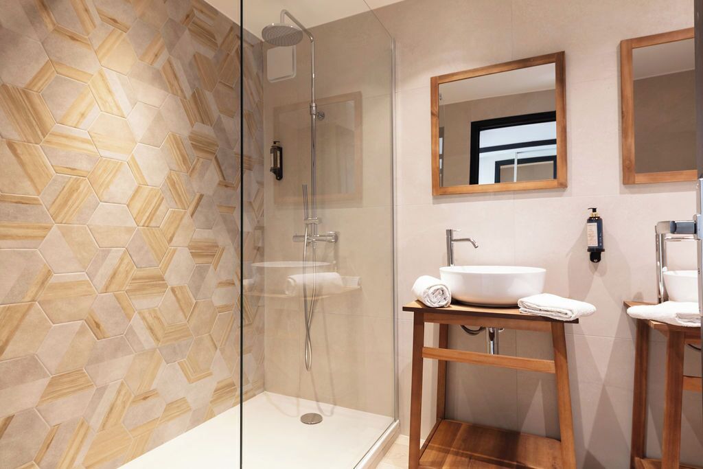 Une salle de bain moderne avec une douche à parois de verre, un meuble-lavabo en bois et un miroir.