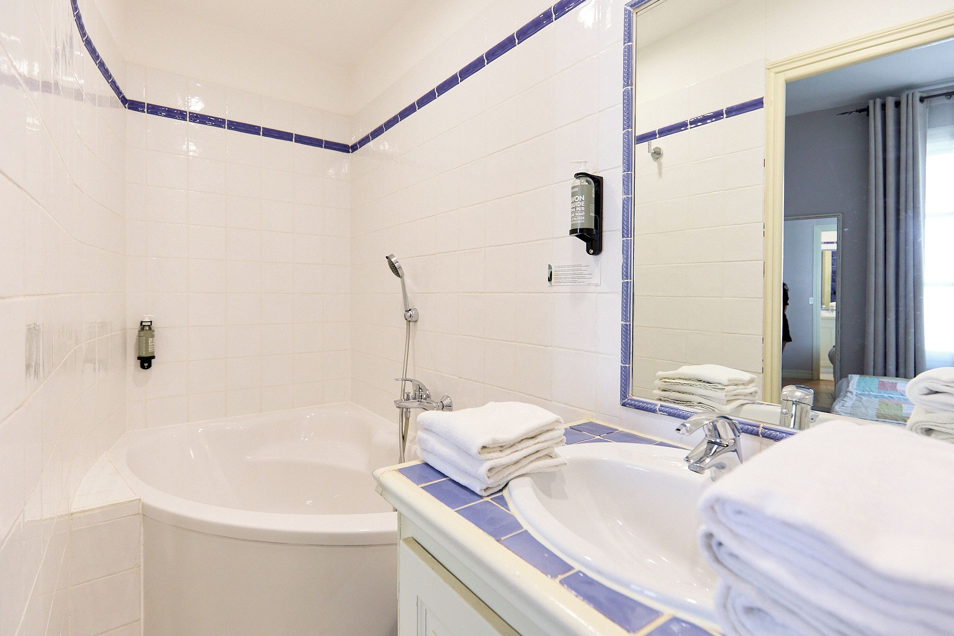 A bathroom with a bathtub, a sink, and a mirror.