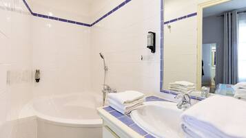 A bathroom with a bathtub, a sink, and a mirror.