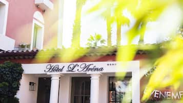 Hotel L'Arène with a sign, columns, and a building facade.