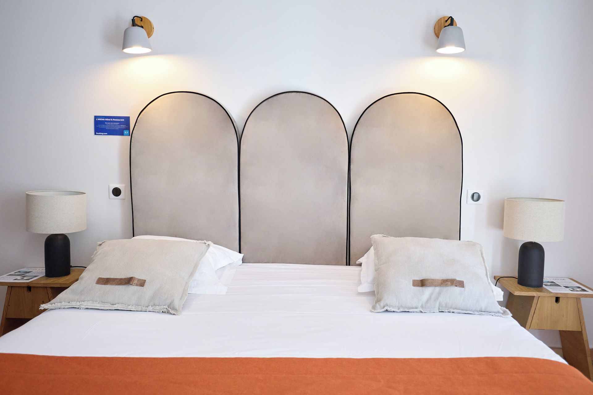 A hotel room with a large bed, two bedside lamps, and a sign indicating the room type.