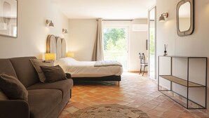A bedroom with a bed, a sofa, a console table, and a mirror. - Hôtel l'Arena (Fréjus)