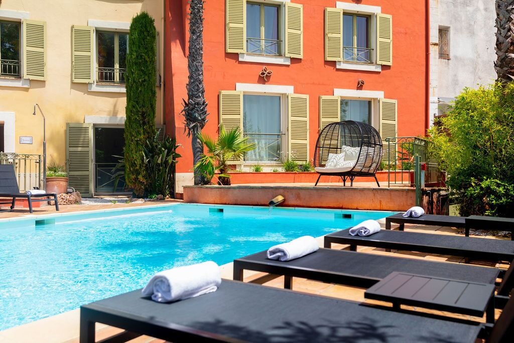 Una piscina amb gandules i una cadira amb estructura metàl·lica.