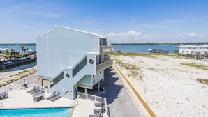 Un immeuble situé en bord de mer, doté d’une piscine, d’un espace extérieur aménagé et offrant une vue sur l’océan.