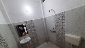 A small bathroom with a sink, toilet, and shower. - Janardan Homestay Lucknow (Lucknow)