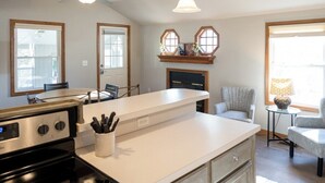 Une cuisine dotée d’un îlot central, d’une cuisinière et d’un coin repas avec des chaises.