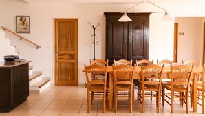 A dining area with a wooden table and chairs, a coat rack, and a staircase. - Quiet family friendly vacation home for 6 to 10 pers. (Cabrieres d' Avignon)