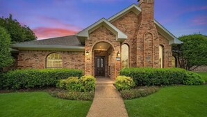 A brick house with a front entrance, a chimney, and a well-maintained lawn. - Stunning Gables House, Basketball Court (Dallas)