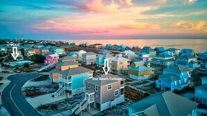 Un quartier résidentiel en bord de mer, avec des maisons aux couleurs vives et un chalet de plage.
