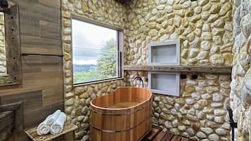 Relax in a bathroom with a bathtub, bench, and stool, offering a view of the outdoors.