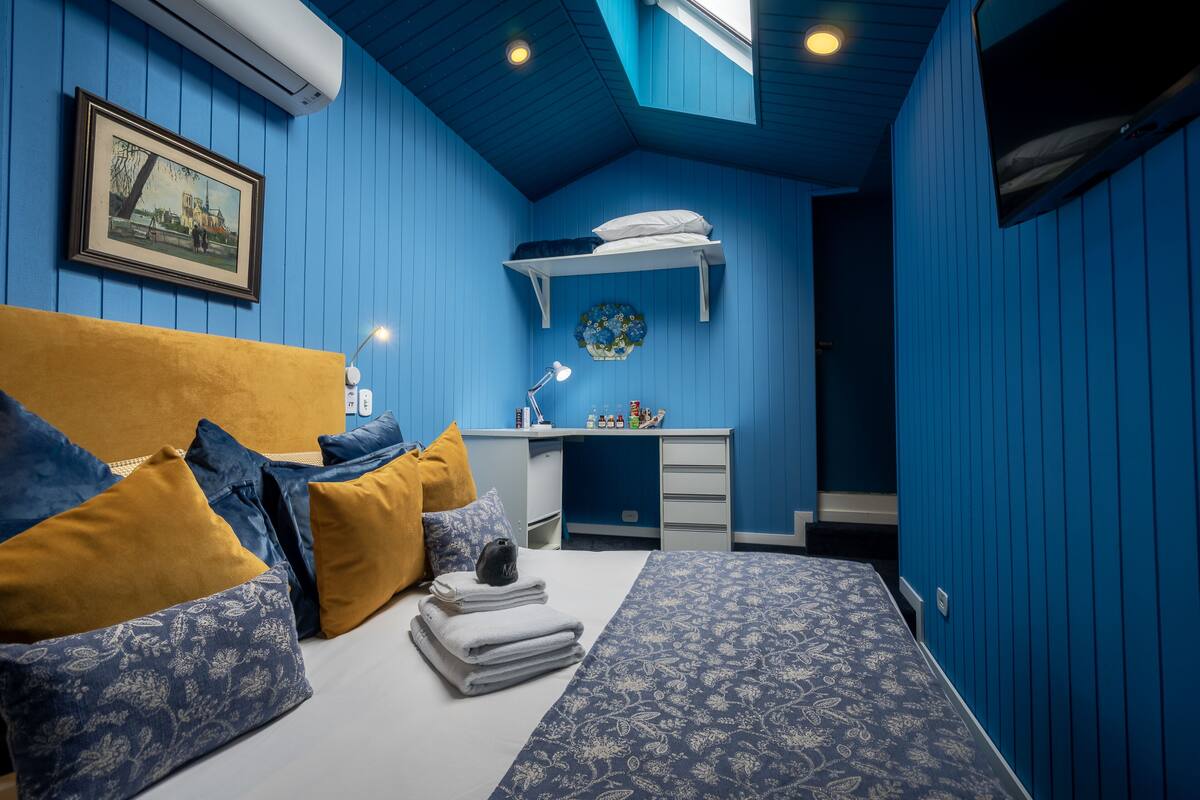 Ein Schlafzimmer mit einem Bett, einem Nachttisch und einem Schreibtisch mit Stuhl.