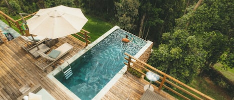 Una piscina al aire libre, sillones reclinables de piscina