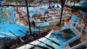 A large indoor swimming pool with multiple lanes, water slides, and a boat-shaped play area. - Jade East Towers~Beach Front w/Amazing Unparalleled  Sunrise and Sunset Views (Jade East Towers , Destin)