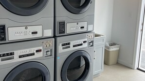 A laundry area with four stacked front-loading washing machines. - Beach block Wildwood Crest ground level condo-103 (Wildwood Crest)