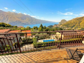 Une terrasse offrant une vue sur un paysage montagneux et un plan d’eau.