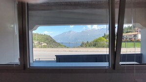 Una finestra con vista su una montagna e un lago.