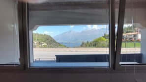 A window with a view of a mountain and a body of water.