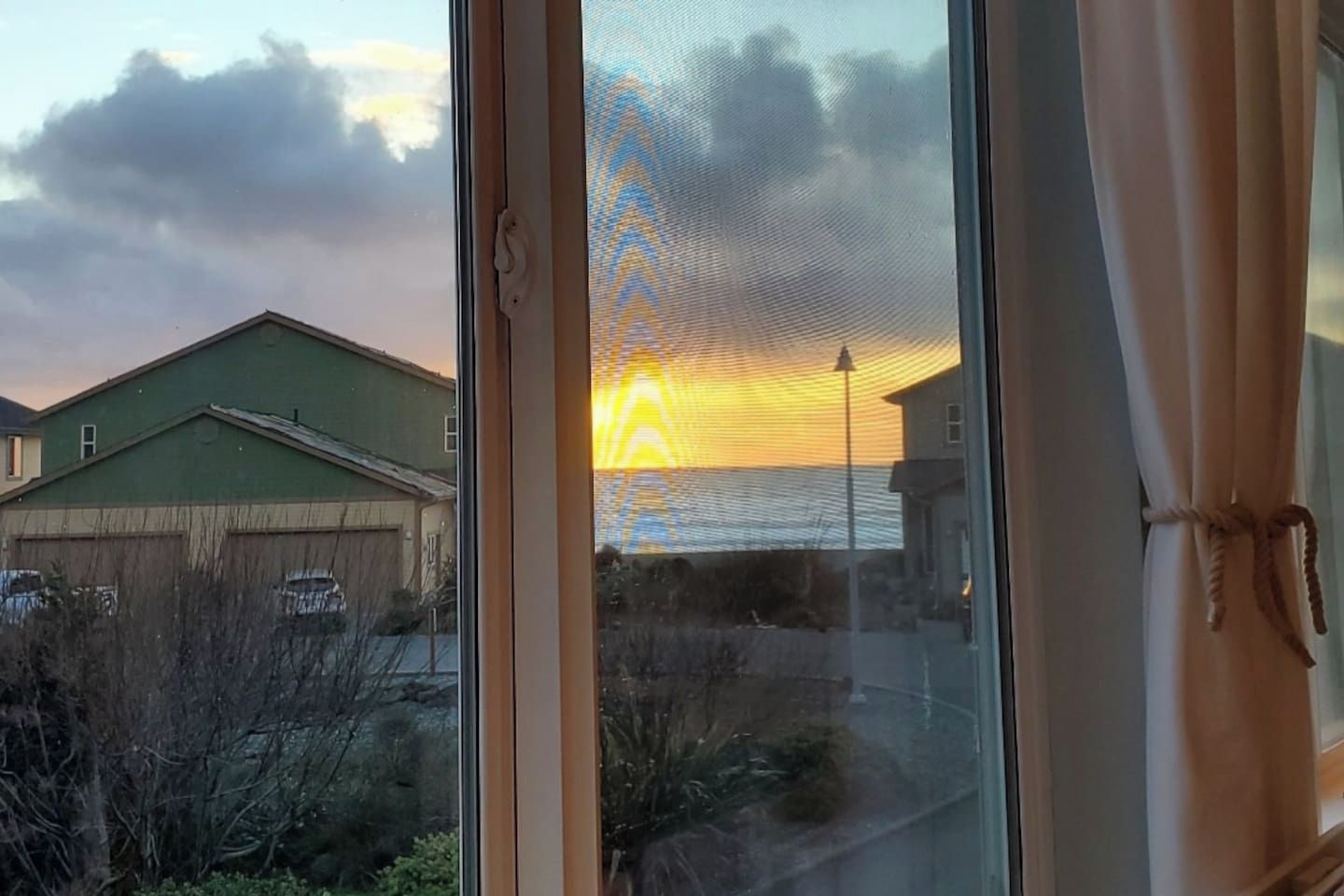 A view through a window with a building and a street outside.