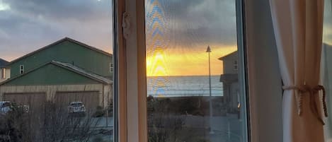 A view through a window with a building and a street outside.