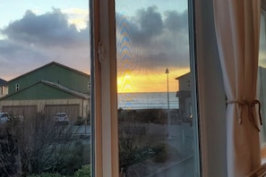 A view through a window with a building and a street outside. - Friends & Family Seaside Retreat, Walk to Beach! (Gold Beach)