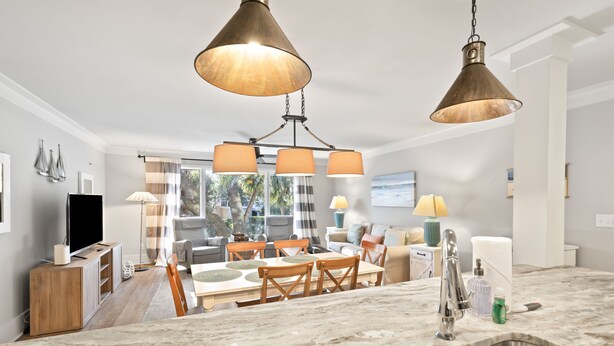 A modern kitchen with a marble countertop, stainless steel sink, and pendant lighting. - Lagoon Villa 43 - Walk to Ocean! Prime Location! (Isle of Palms)
