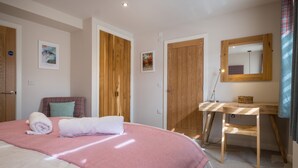 Ein Schlafzimmer mit einem Bett, einem Schreibtisch und einem Spiegel.